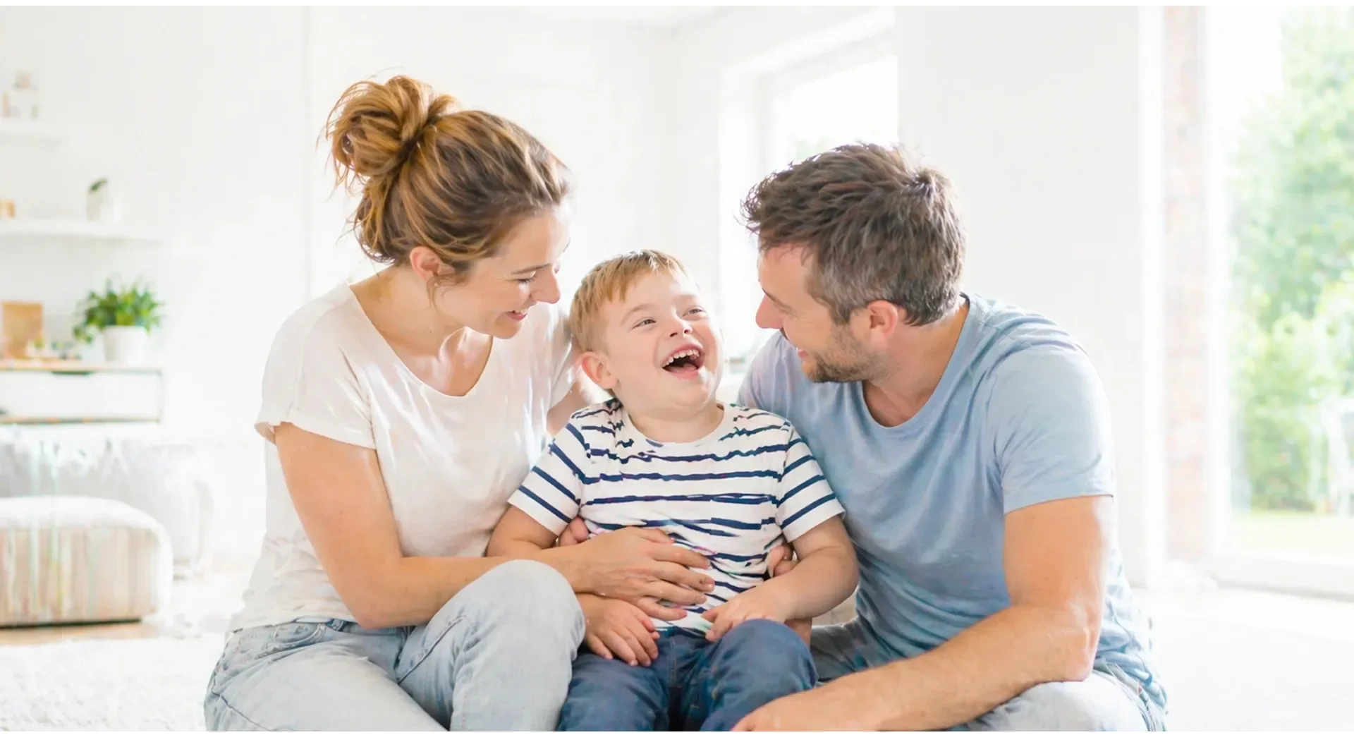 Eltern lachen mit ihrem Kind auf dem Sofa