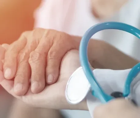 Hände halten fürsorglich die Hand einer Seniorin